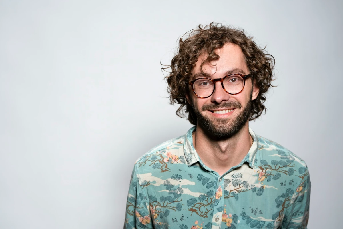 Photo d’origine d’un homme portant des lunettes, une barbe et une chemise à motifs